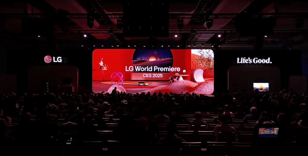 Auditorio lleno durante la LG World Premiere en el CES 2025, con una pantalla gigante que muestra el lema "Life's Good" y un escenario rojo con visuales futuristas.